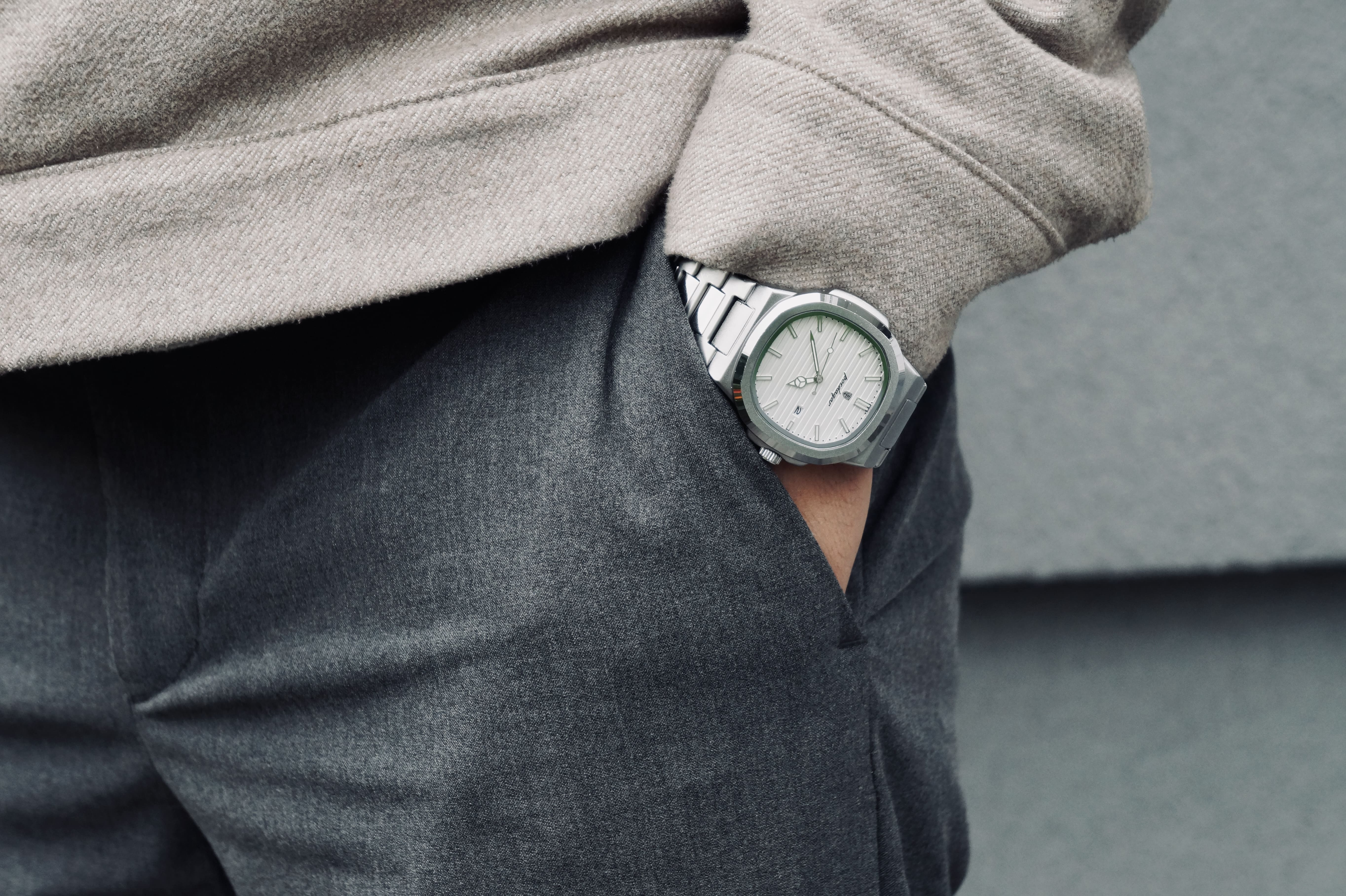 Person wearing a watch with a neutral background